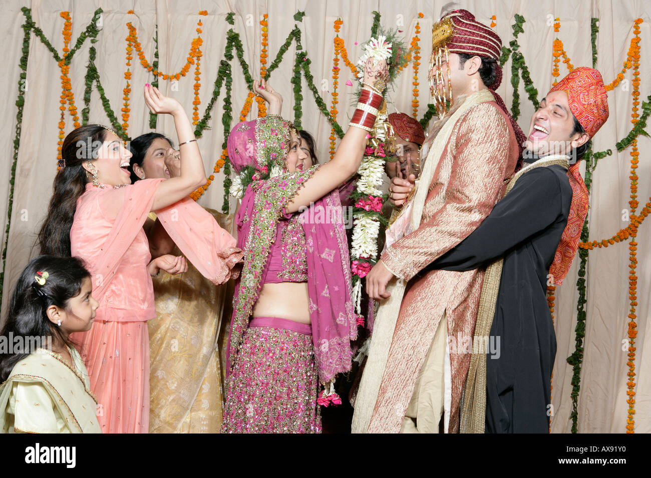 Sposa e lo sposo sposarsi con i loro parenti il tifo intorno a loro Foto Stock