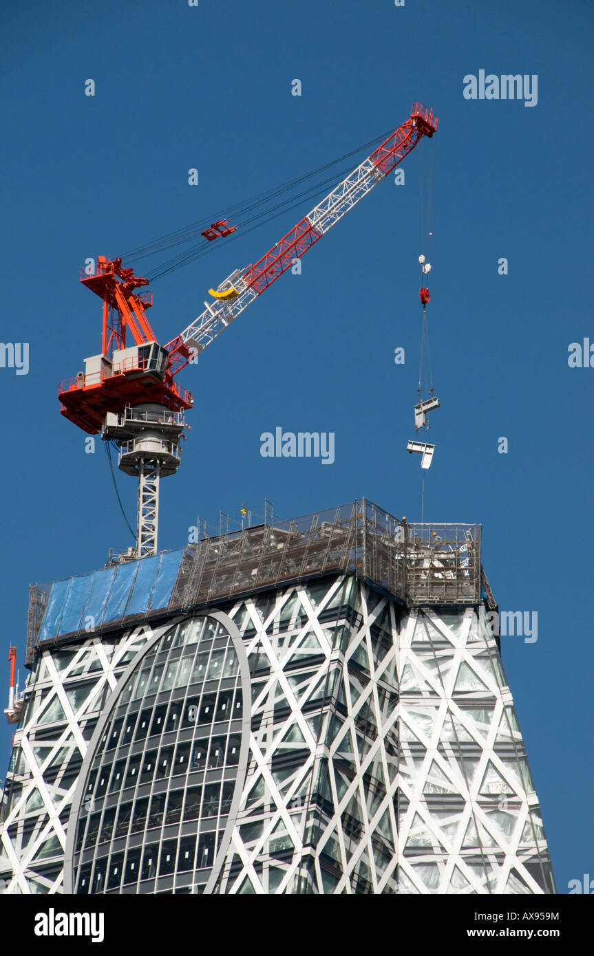Gru su Tokyo Mode Gakuen Cocoon Tower in costruzione in Shinjuku, Tokyo, Giappone Foto Stock