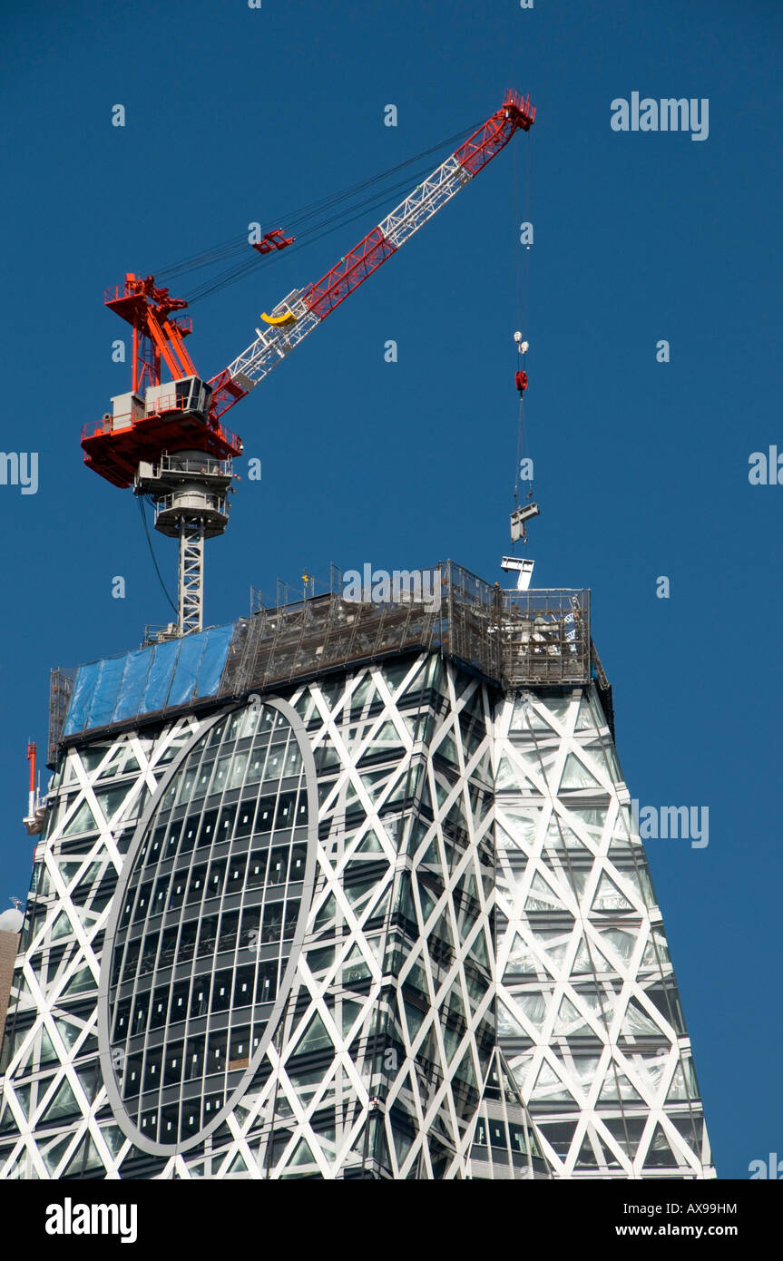 Gru su Tokyo Mode Gakuen Cocoon Tower in costruzione in Shinjuku, Tokyo, Giappone Foto Stock