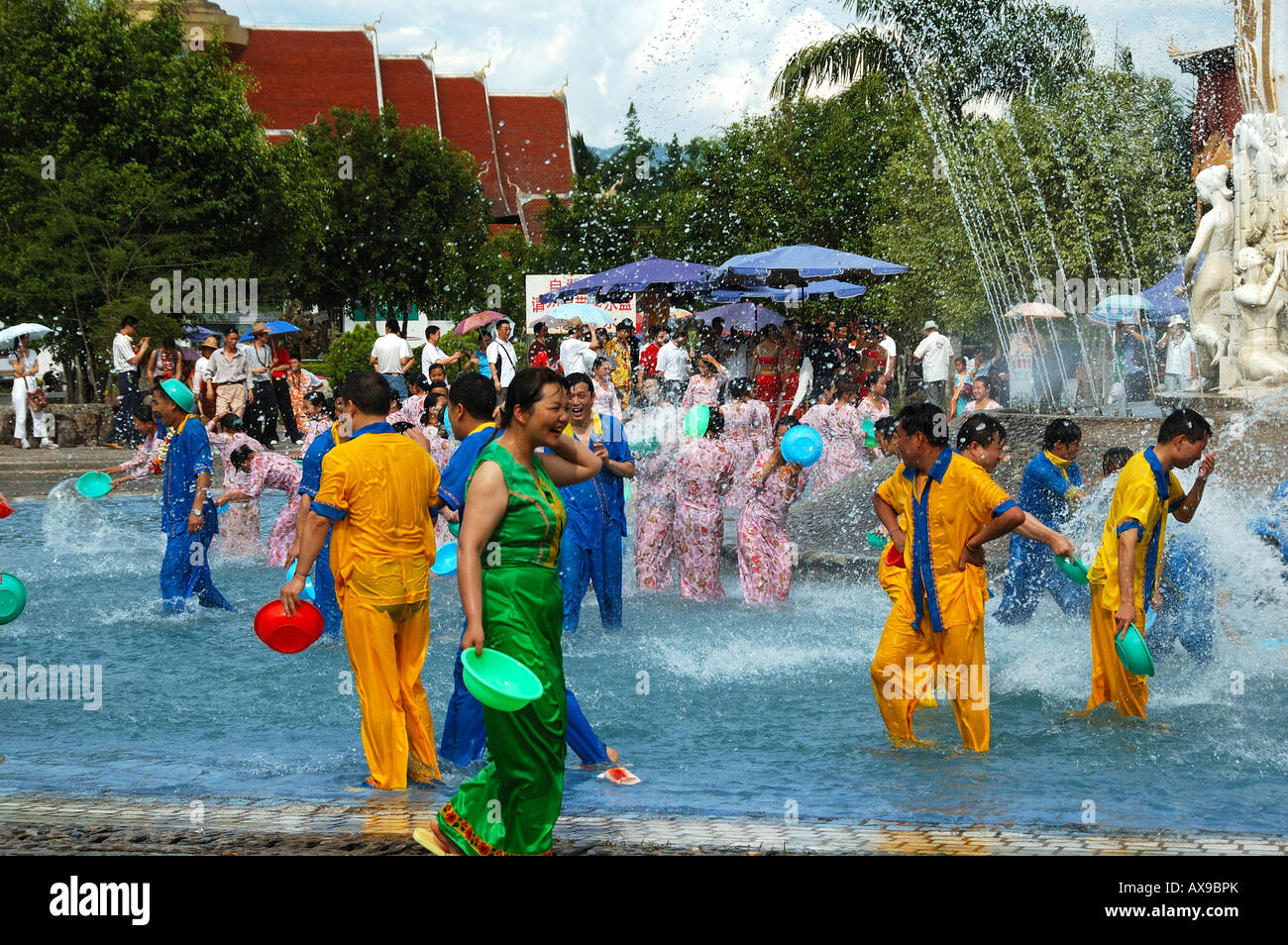 Festival in un villaggio Dai, persone splash acqua ad ogni altro per buona fortuna. Xishuanbanna, Yunnan, Cina Foto Stock