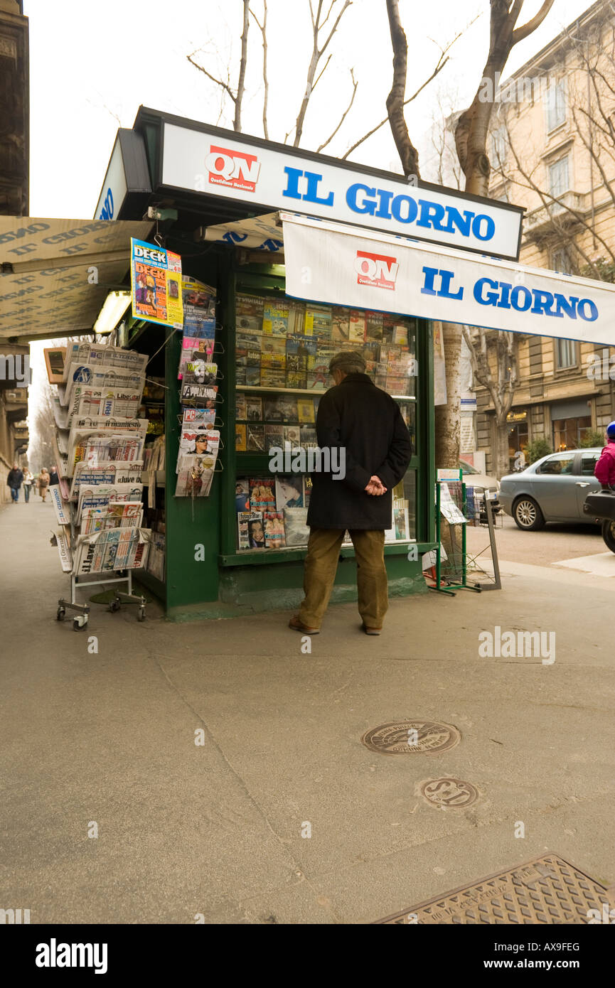 Un italiano uomo accede riviste presso un chiosco sul marciapiede lungo il corso Magenta milano italia Foto Stock