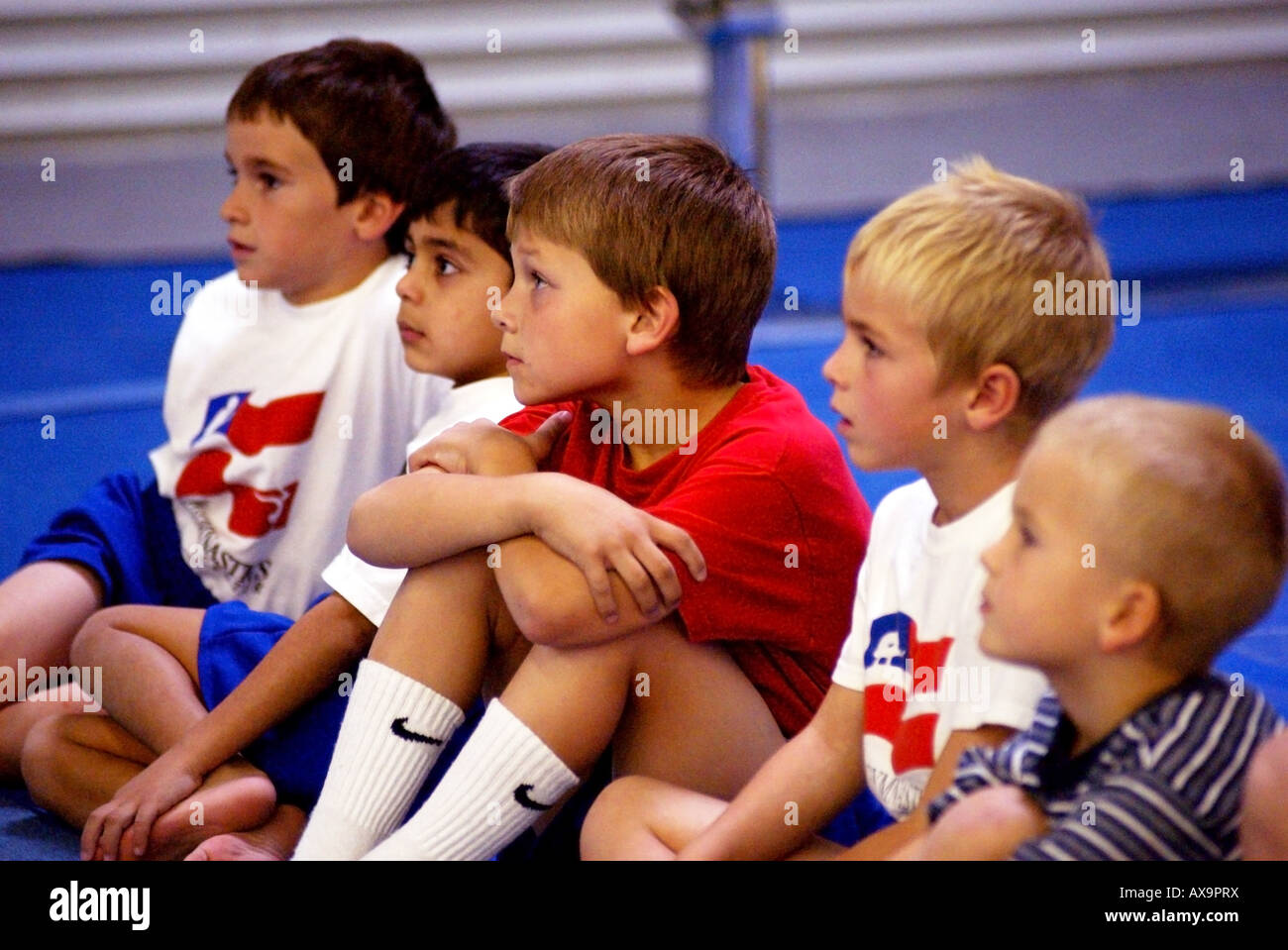 Un gruppo di ragazzi di attendere il loro turno per competere durante la dimostrazione ginnastica soddisfare Foto Stock