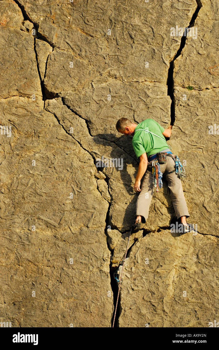 Uno scalatore su una roccia calcarea faccia Foto Stock