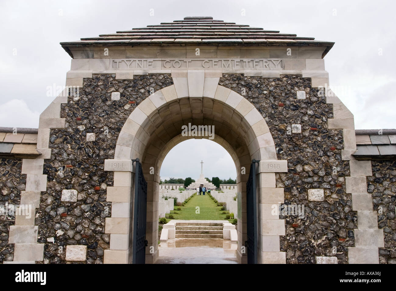 Ingresso archway a Tyne Cot - la più grande British cimitero militare in tutto il mondo - con la croce del sacrificio visibile in distanza Foto Stock
