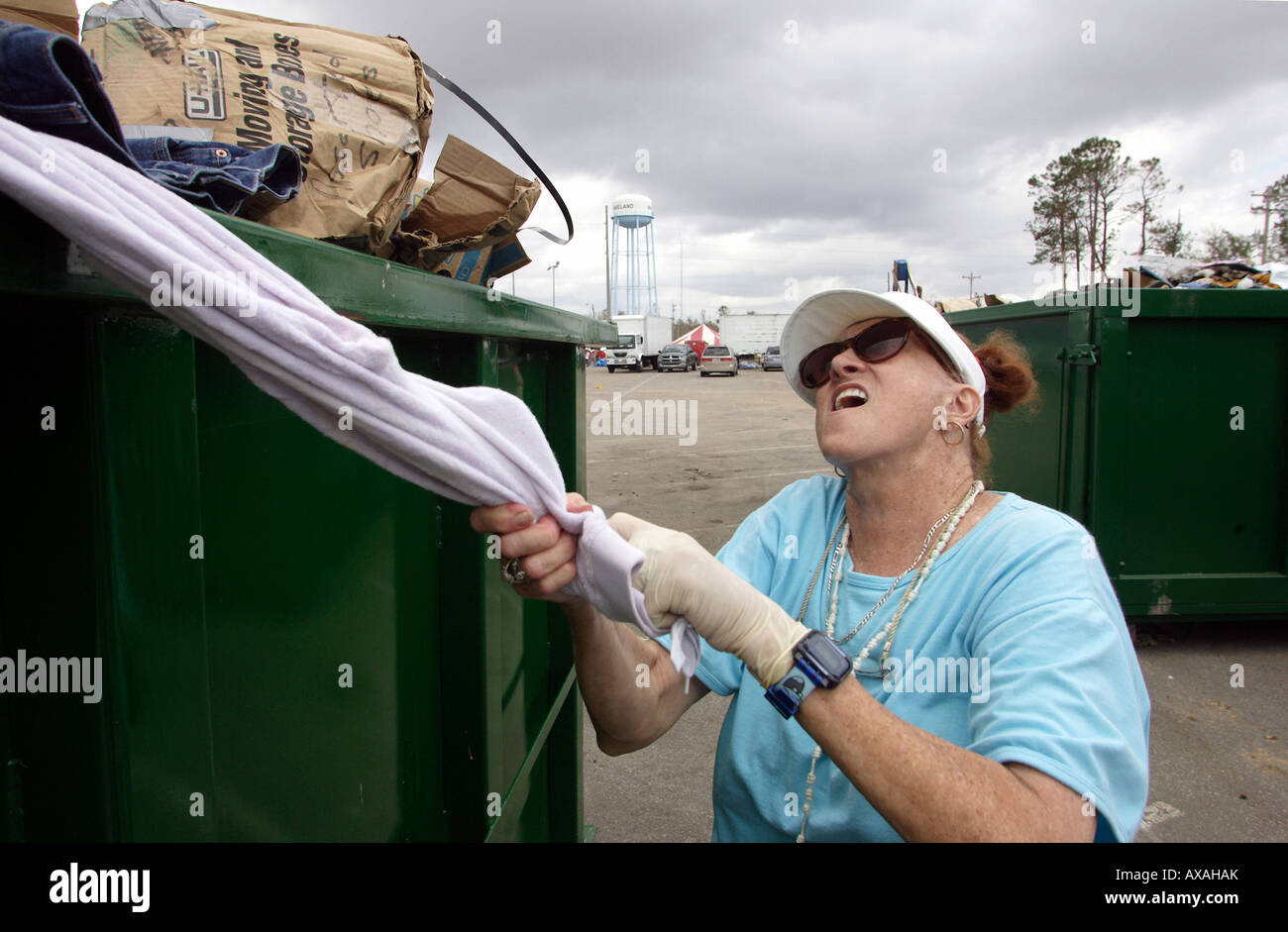Donna abiti di tiro fuori di contenitori per rifiuti, Waveland, STATI UNITI D'AMERICA Foto Stock