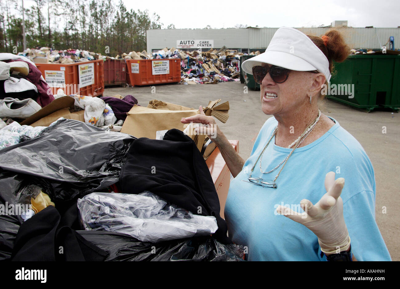 Donna abiti di tiro fuori di contenitori per rifiuti, Waveland, STATI UNITI D'AMERICA Foto Stock