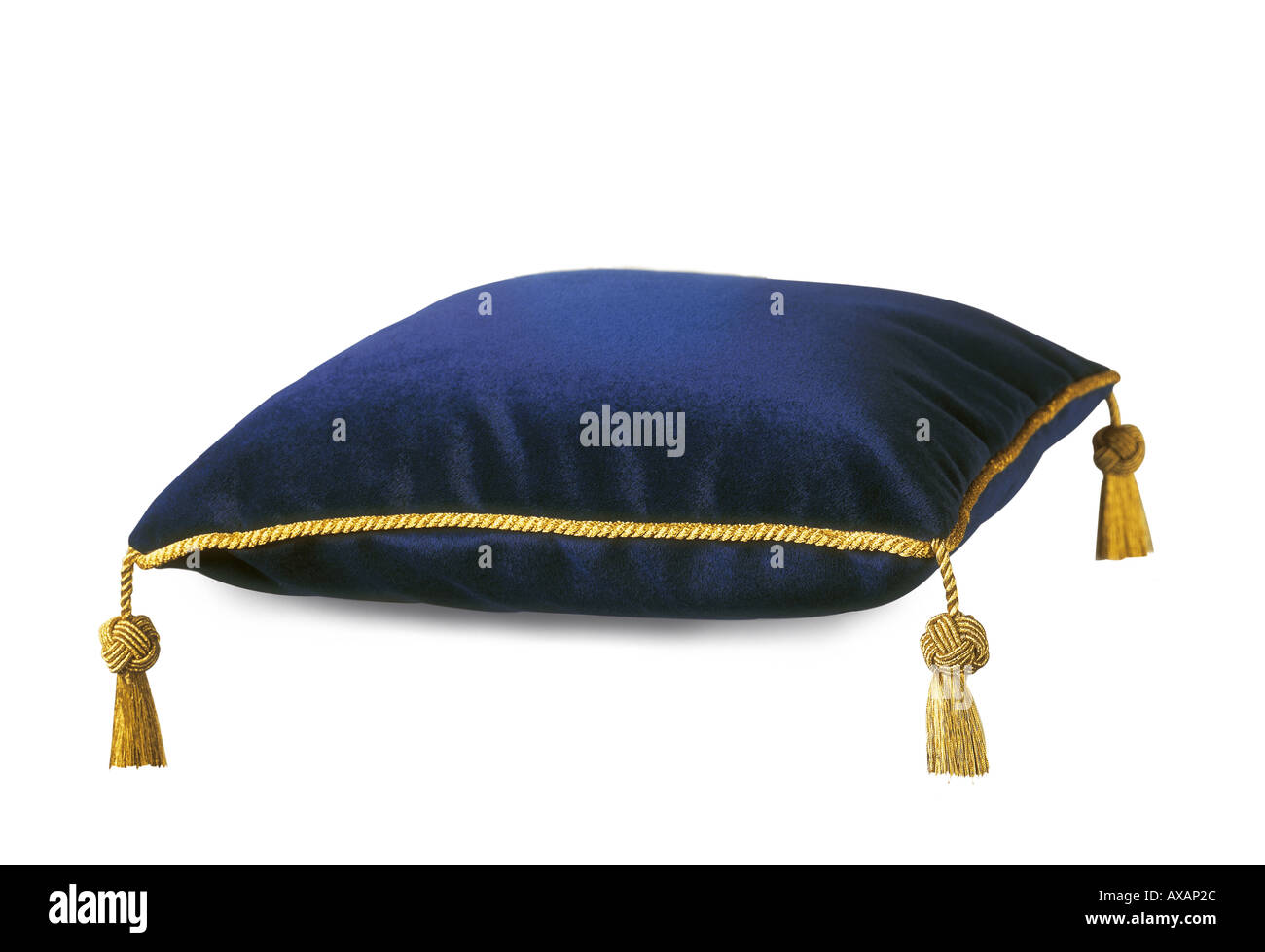 Una Royal ricchi tessuti di seta cuscino di lusso profondo colore blu con costose nappe oro su sfondo bianco Foto Stock