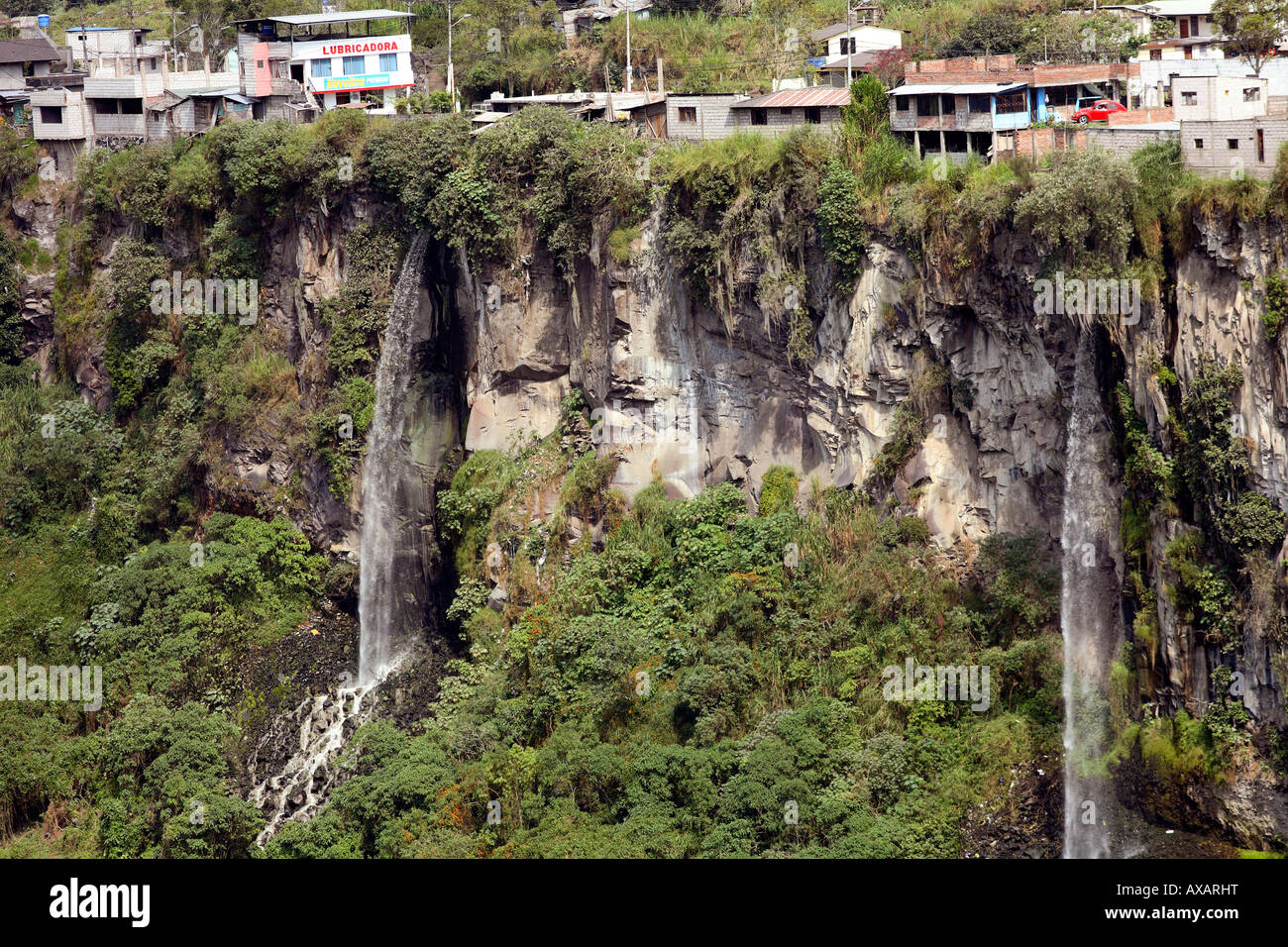 Edifici appollaiato sul bordo di una scogliera di basalto, parte della città di Banos, Ecuador Foto Stock