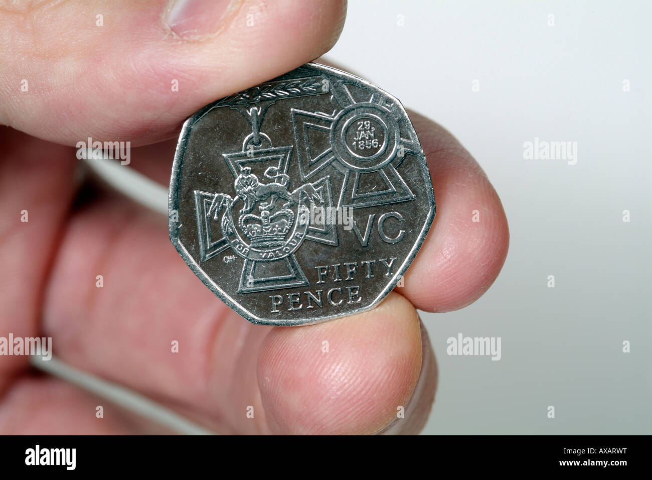 VC cinquanta Pence pezzo tenuto tra il pollice e il dito Foto Stock
