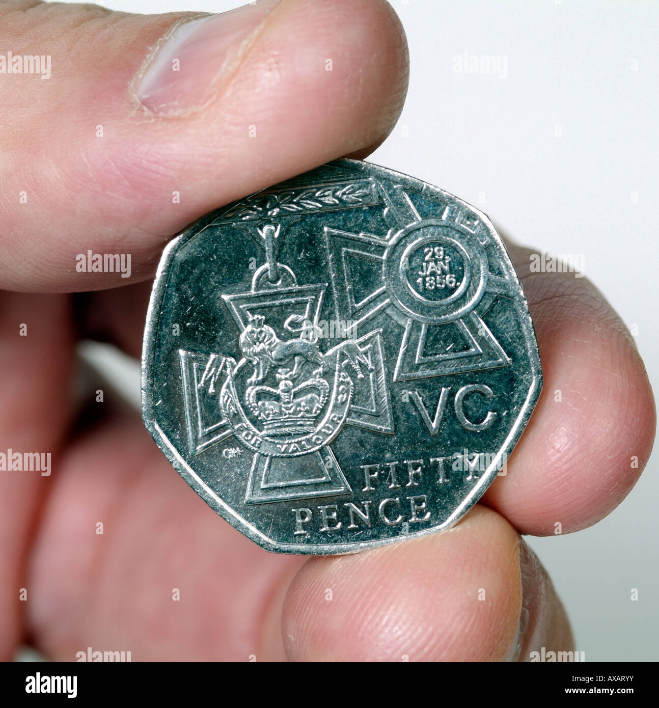 VC cinquanta Pence pezzo tenuto tra il pollice e il dito Foto Stock