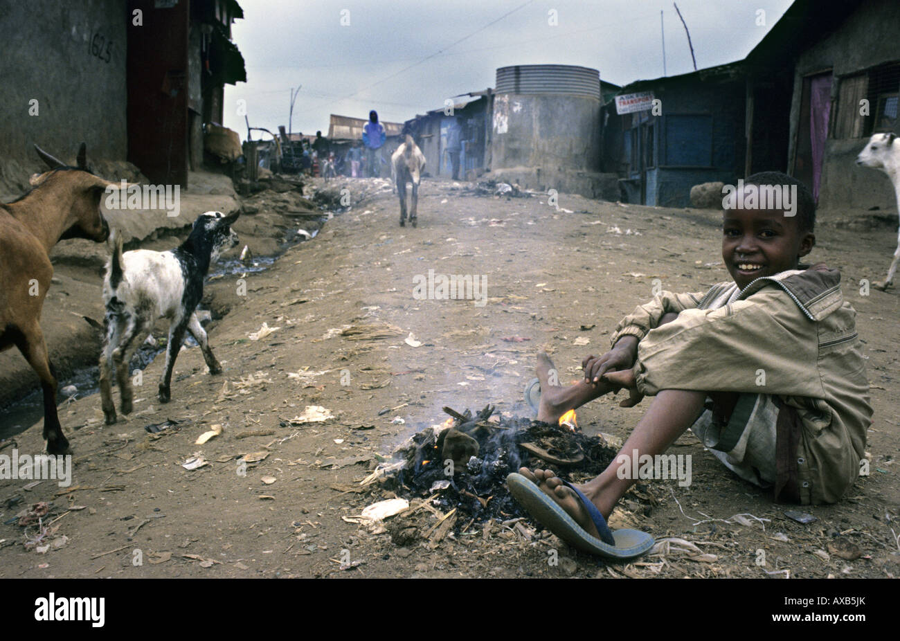 Kid giocando con il fuoco in Kibera strade, le bidonville in Africa - Nairobi, Kenya Foto Stock