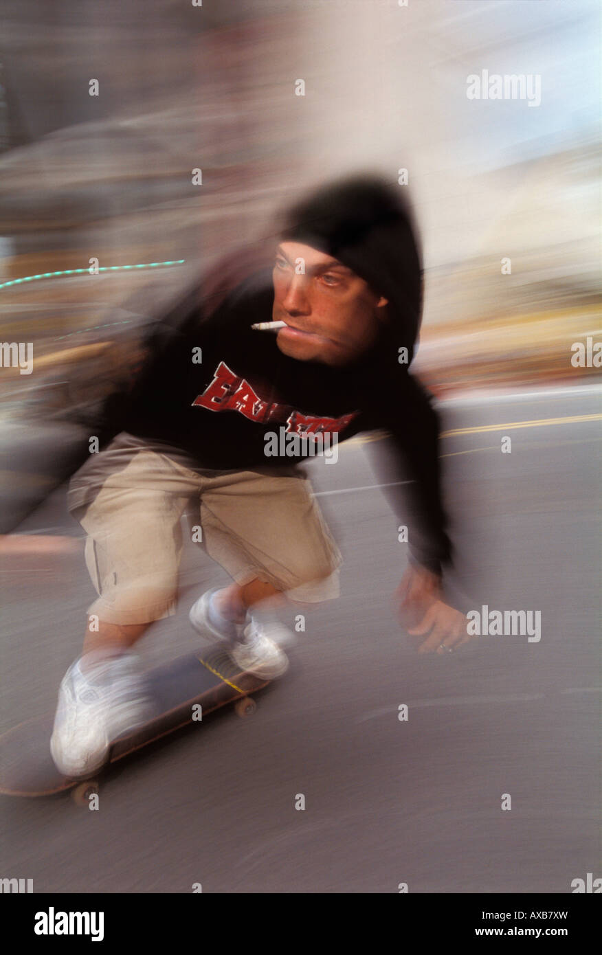 Un guidatore di skateboard velocità attraverso la città mentre si fuma una  sigaretta Foto stock - Alamy