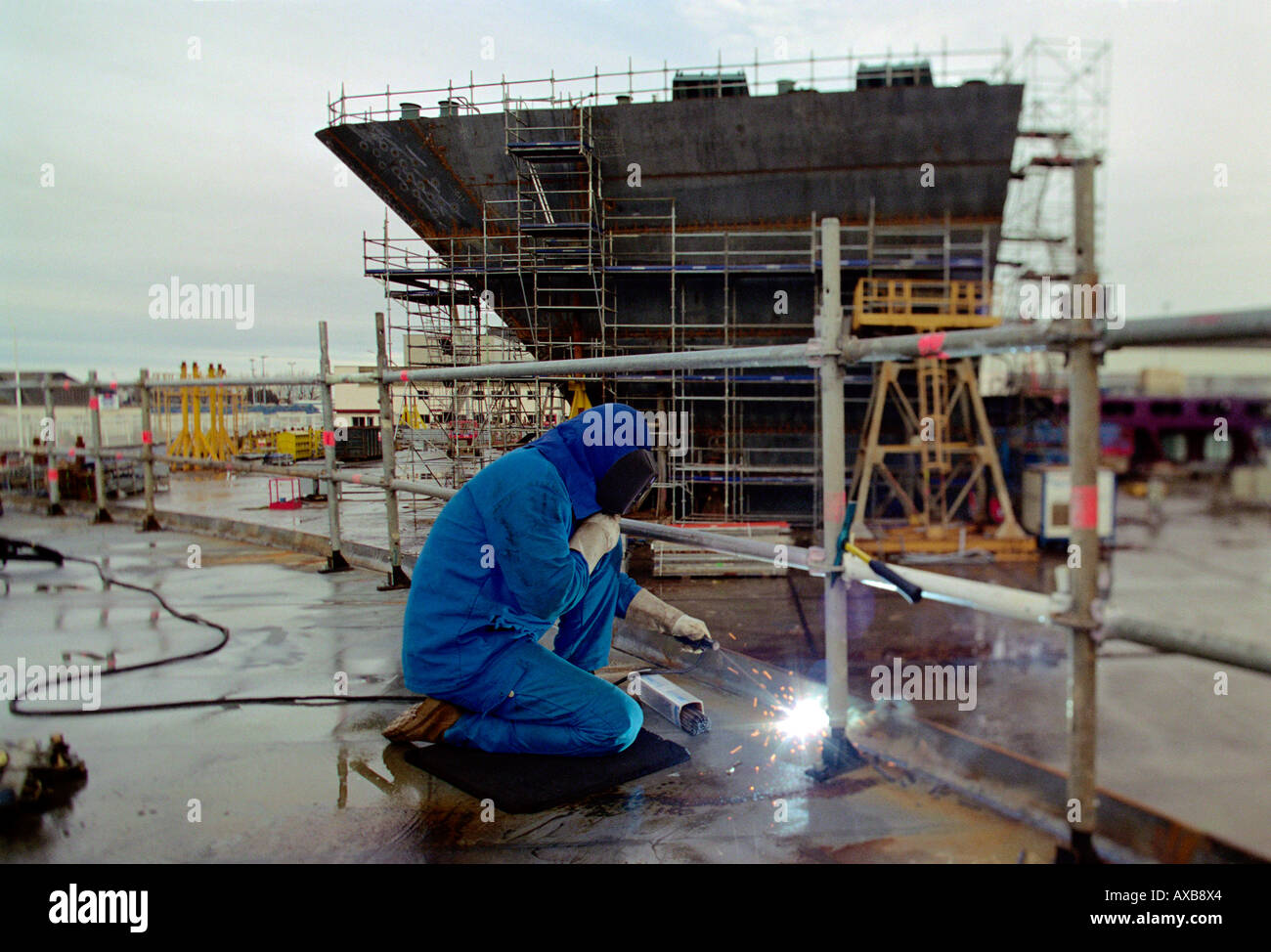 Lavoratore di saldatura delle piastre in acciaio, bacino di carenaggio, Queen Mary 2, Saint-Nazaire Francia Foto Stock