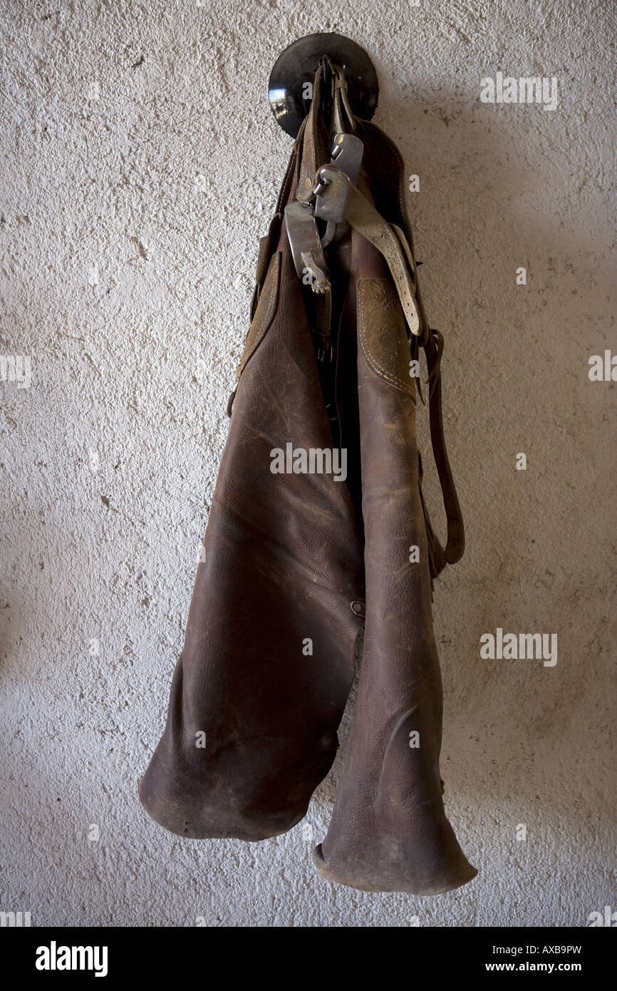 Carichi di pelle del Messico chaps e speroni impiccato in un ranch stabile Foto Stock