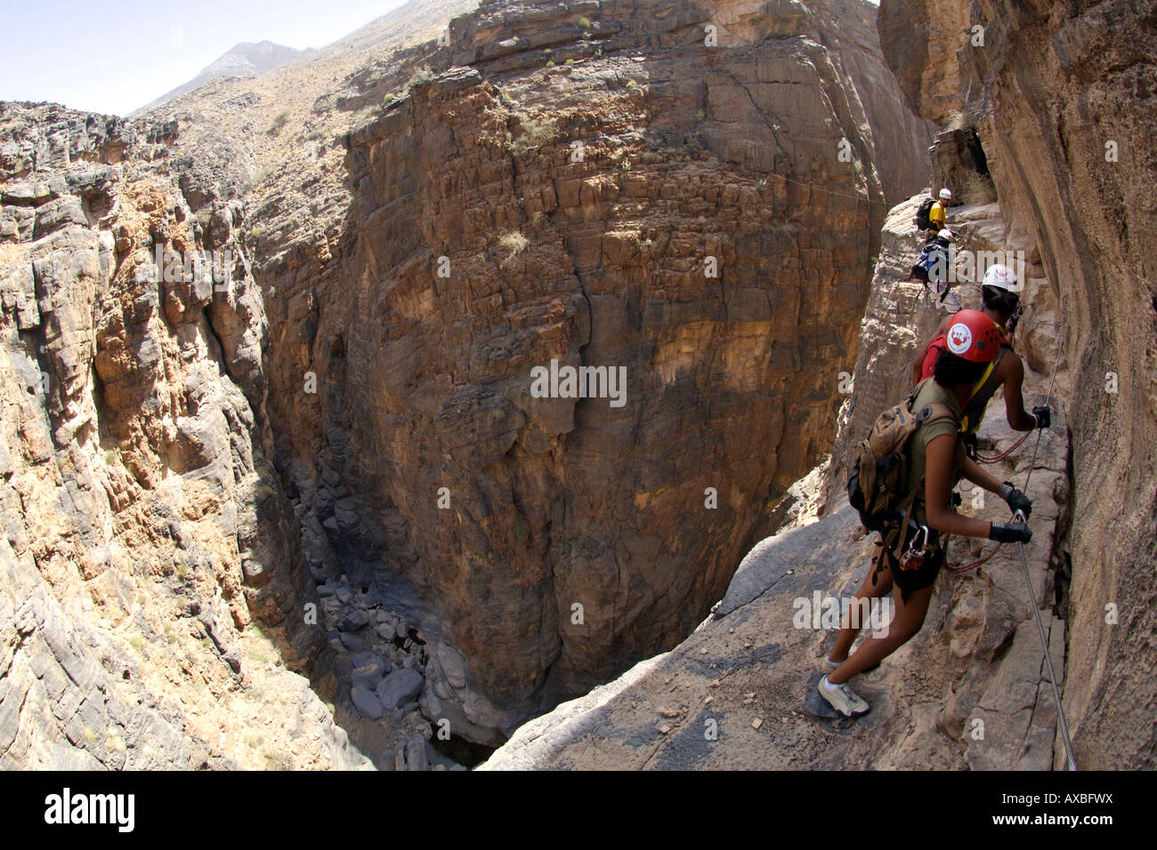 Gli escursionisti facendo la Via Ferrata escursione nel Canyon di serpente in Jebel Akhdar del western montagne Hajar in Oman. Foto Stock