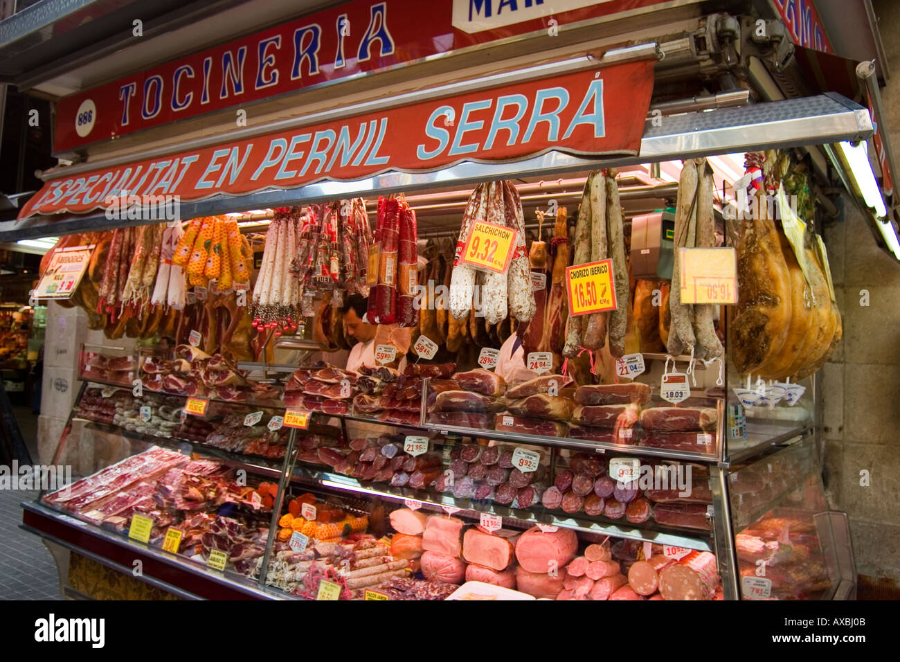 Barcelona Ramblas market hall la carne Boqeria stallo con prosciutto spagnolo Jammon prosciutto Serrano è appeso su garretti Foto Stock