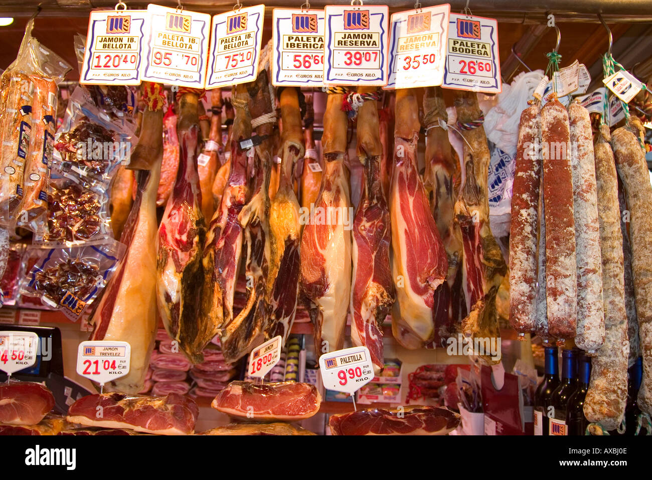 Barcelona Ramblas market hall la carne Boqeria stallo con prosciutto spagnolo Jammon prosciutto Serrano è appeso su garretti Foto Stock
