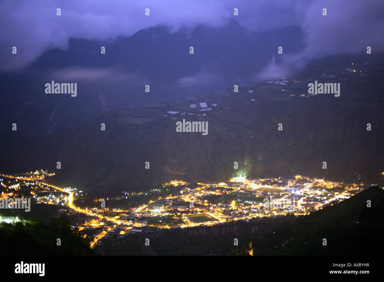 La città di Banos, una destinazione turistica ai piedi del vulcano Tunguragua, Ecuador illuminata di notte. Foto Stock