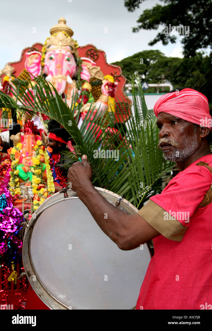 Uomo a suonare la batteria a Ganesh Ganesh Chaturthi, India Foto Stock