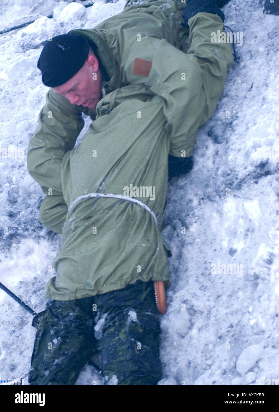 Il salvataggio di un istruttore che è caduto attraverso il ghiaccio per sottoporre a test l'ipotermia al primo soccorso di sopravvivenza delle competenze settimana danese Forze Speciali Foto Stock
