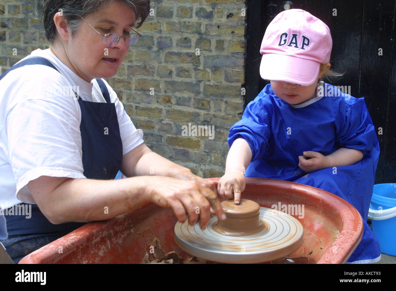 Scuola materna insegnante insegnamento bambino in ceramica su una ruota Foto Stock
