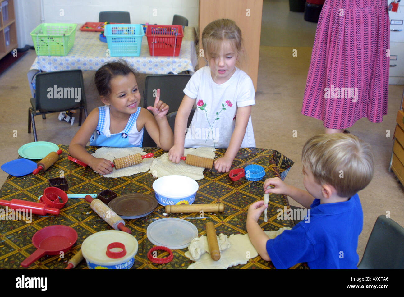 La scuola materna di bambini che giocano con pasta di riproduzione Foto Stock