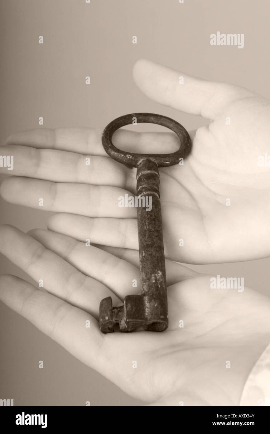 Tenendo un grande vecchia chiave nel palmo delle mani Foto Stock