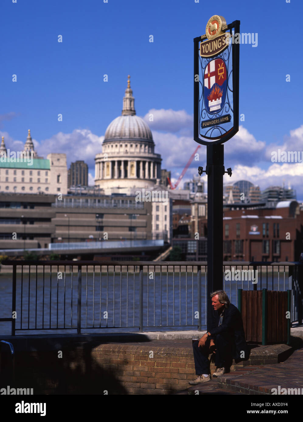 L uomo si ferma per una pinta di birra al di fuori di un pub con la Cattedrale di St Paul e il fiume Tamigi in background Foto Stock