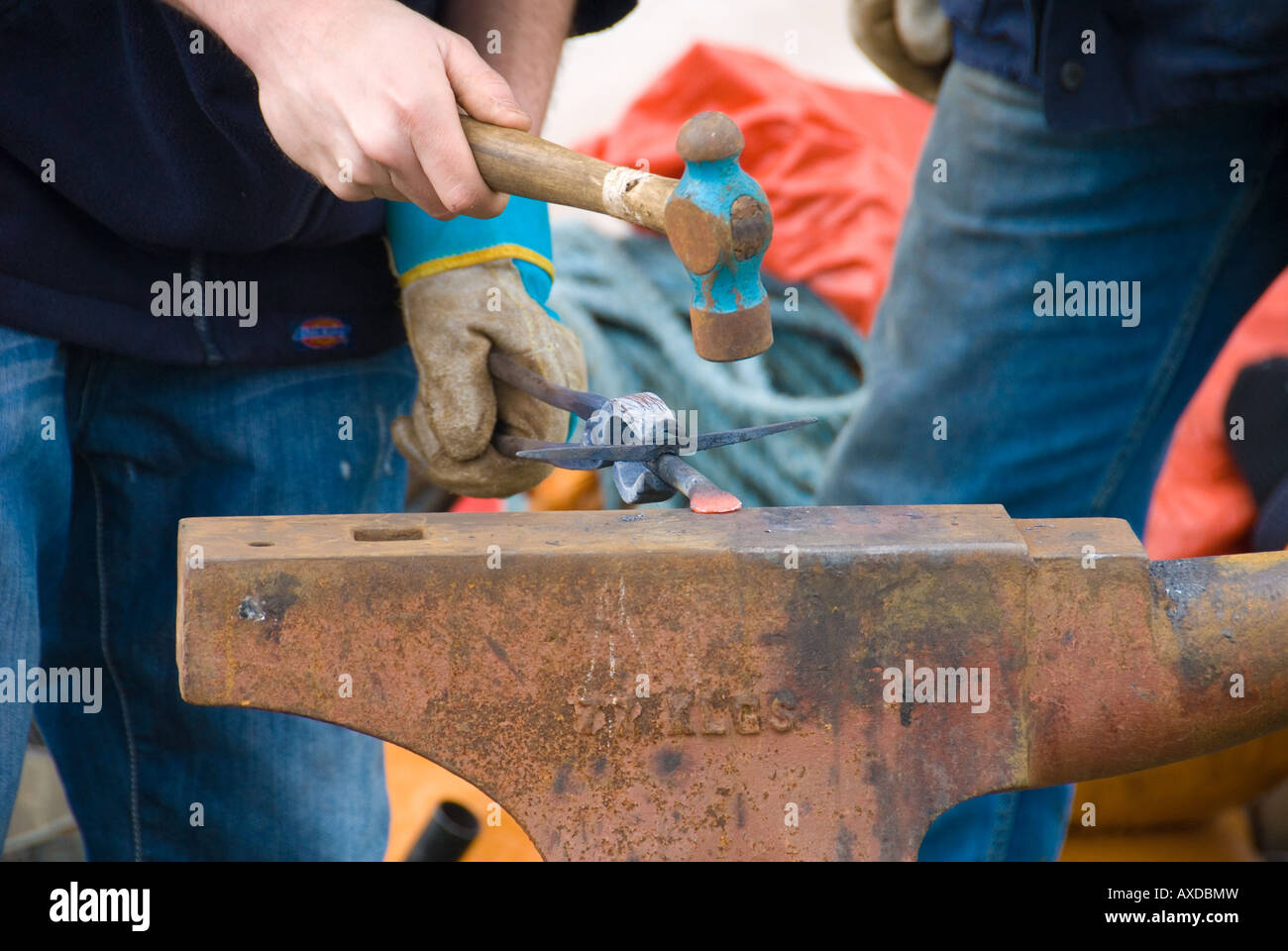 Un fabbro battendo alcuni elementi in ferro battuto con un martello su un'  incudine Foto stock - Alamy