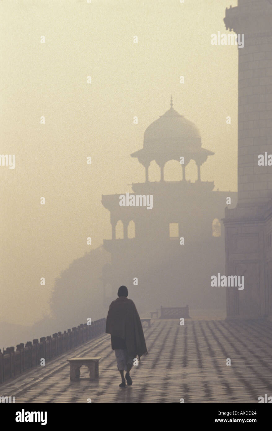 Un India uomo cammina avvolta nella nebbia intorno al Taj Mahal in Agra India Foto Stock