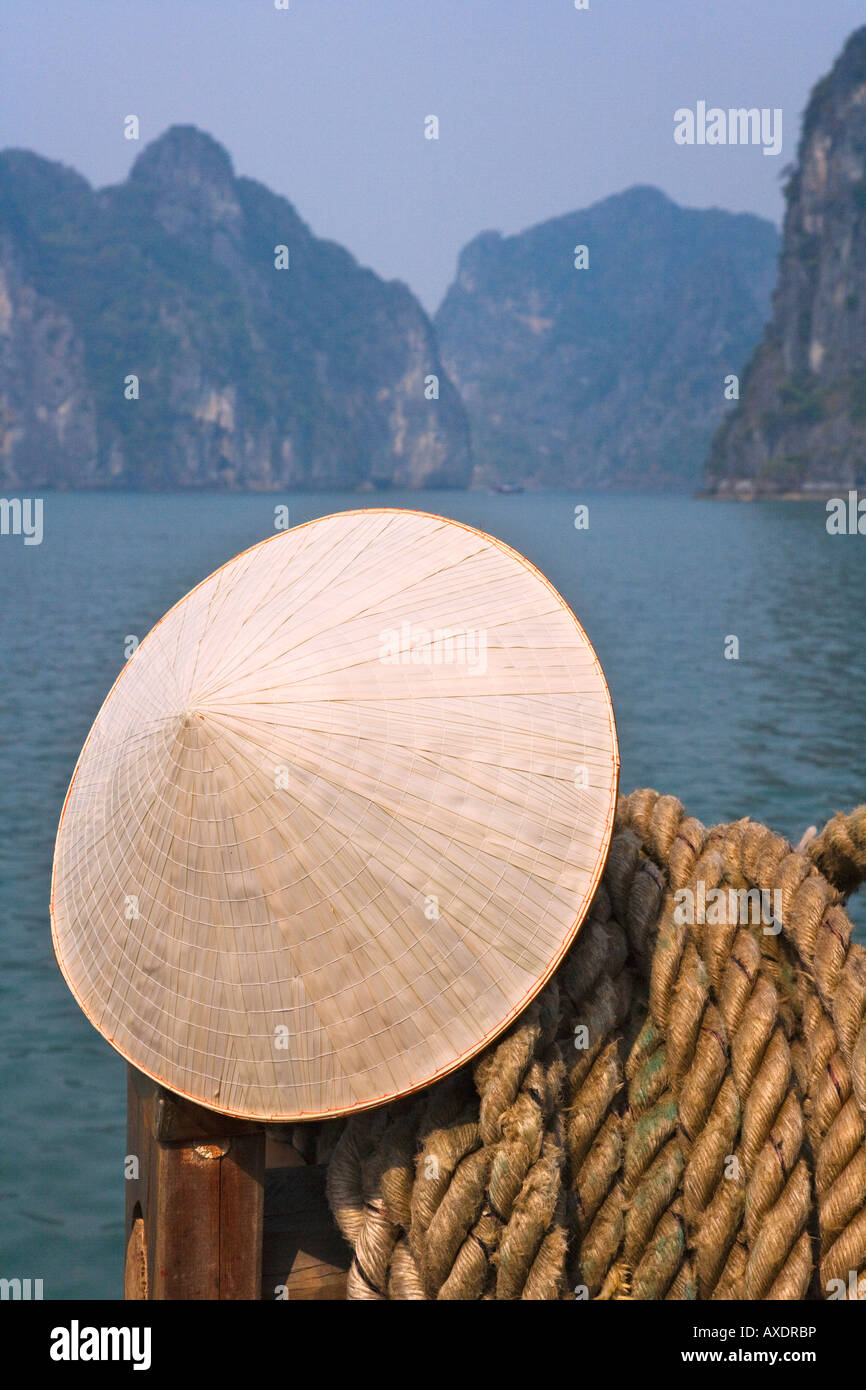 Cappello conico sulla barca di posta indesiderata e del carso isole nella baia di Halong Vietnam Foto Stock