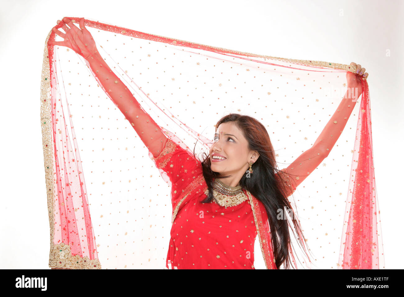 Donna che mantiene la sua dupatta e sorridente Foto Stock