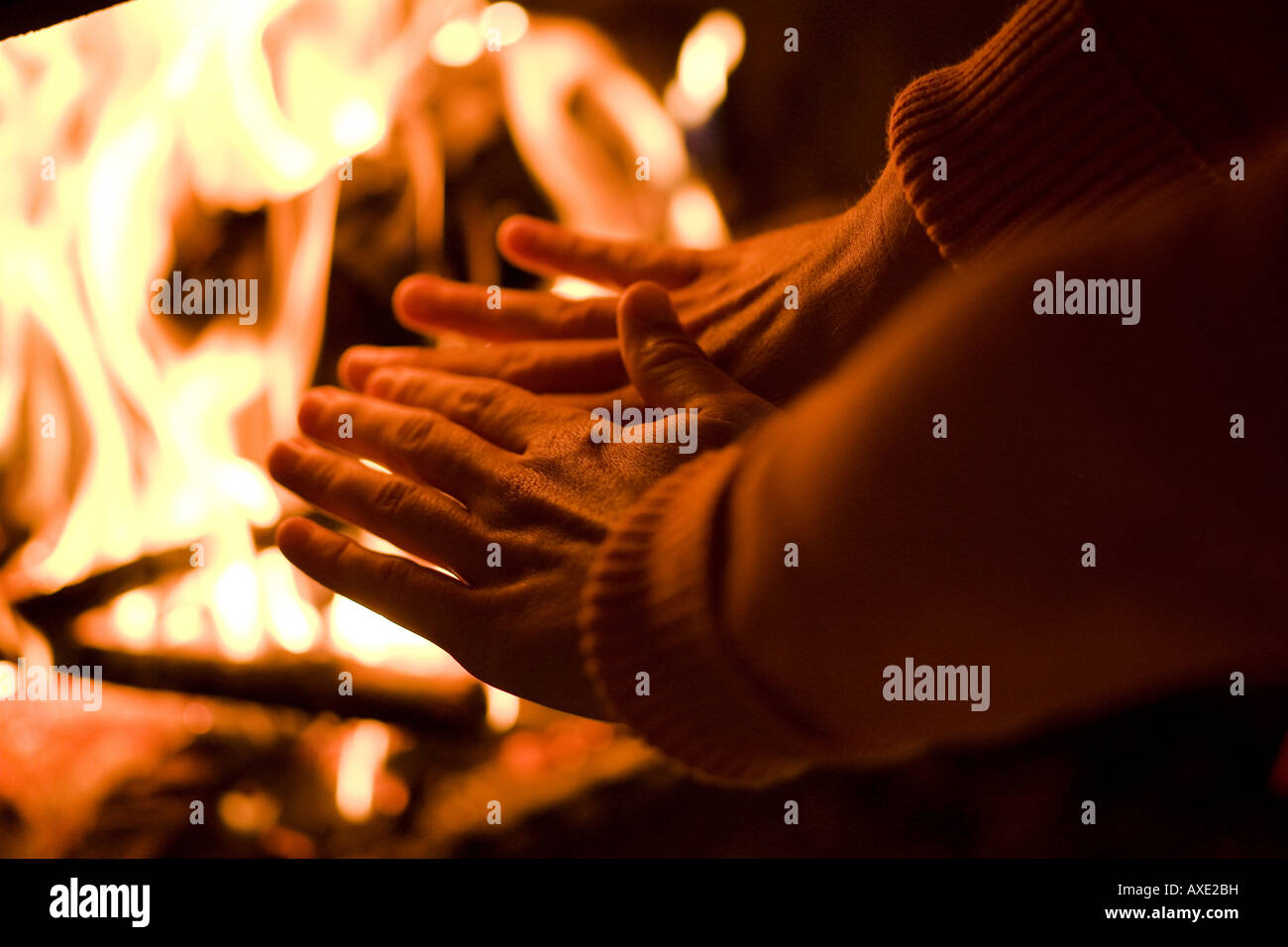Persona riscalda le loro mani su un fuoco Foto Stock