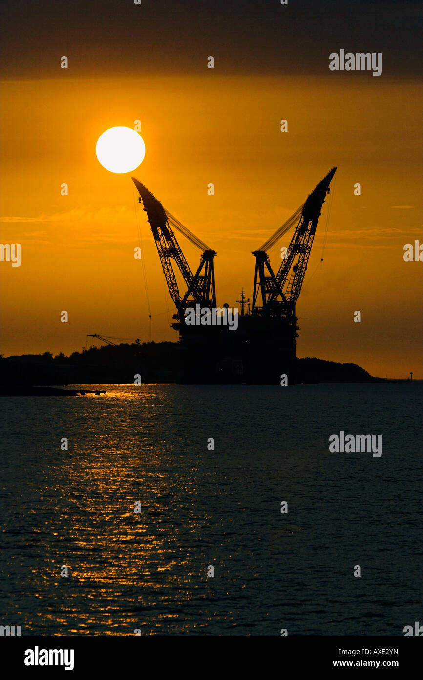 Set di sole behand un enorme twin gru piattaforme Foto Stock