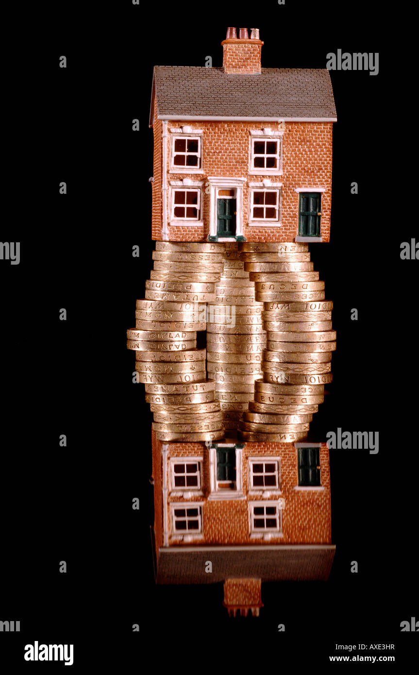 Una casa affondata in debito con la sterlina britannica delle monete in euro Foto Stock