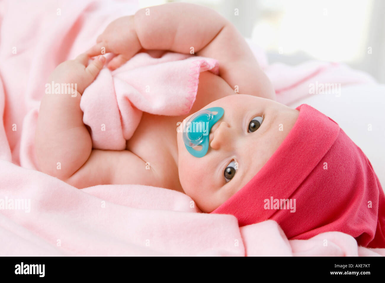 Baby girl (6-9 mesi) giacente sul retro Foto Stock
