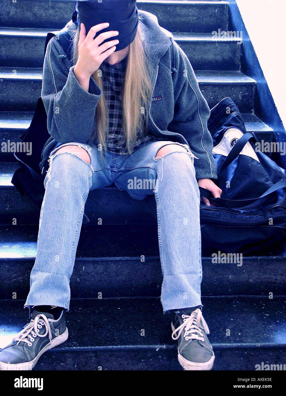 Ragazza ragazzo età 15 20 teen senzatetto bionda bionda sedersi preoccupare preoccupato per il farmaco a compierli addicted junkie jeans thorn cappuccio Felpa Foto Stock