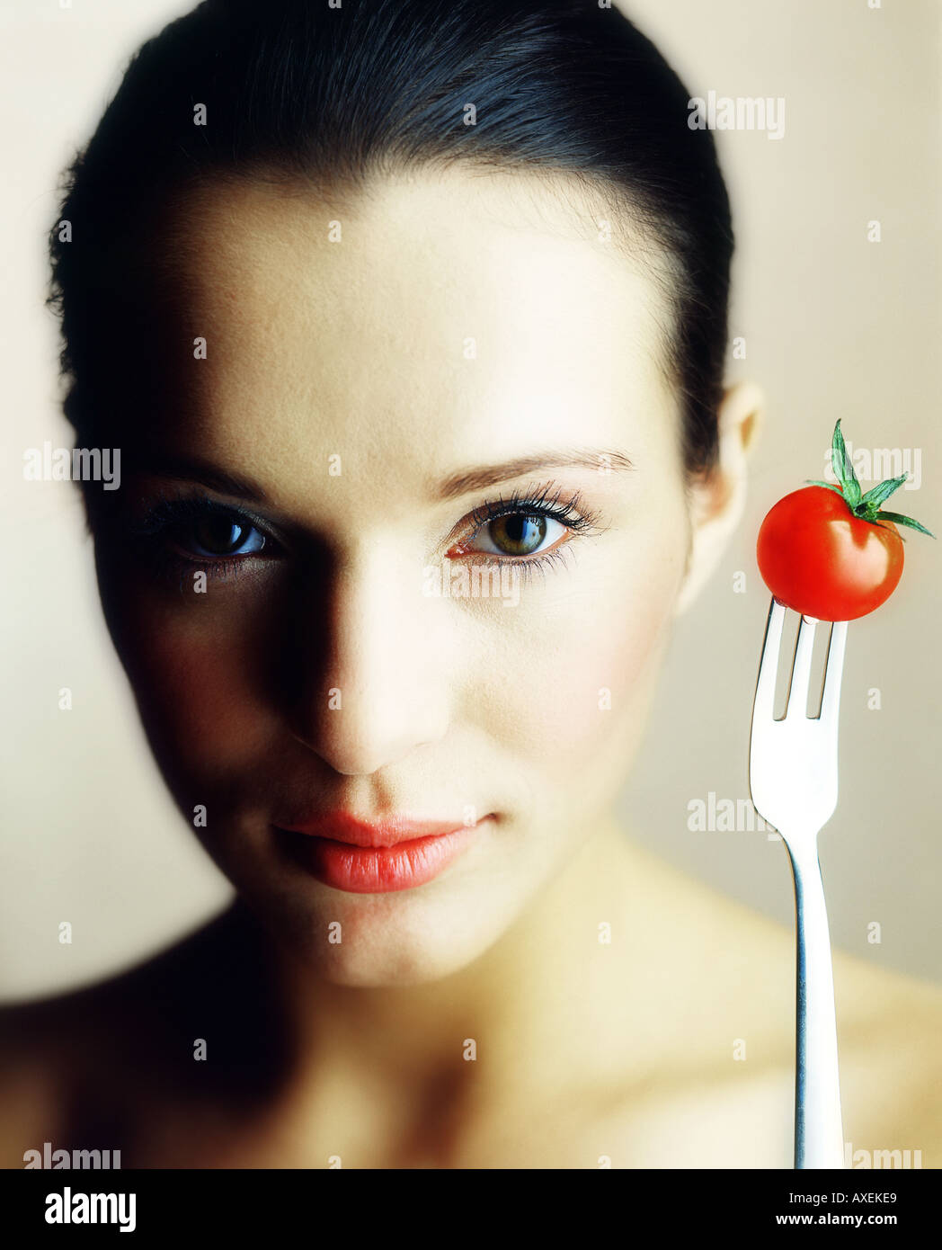 Donna ragazza mloda 15 20 faccia compongono brunette forcella vegetali di pomodoro stick incollata gioioso allegro studio vitamine dieta vegetar Foto Stock
