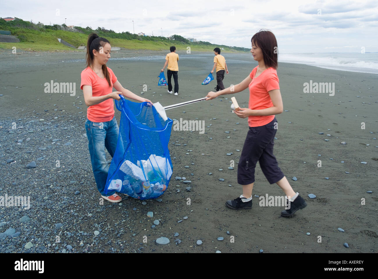 Giovani spiaggia di pulizia Foto Stock