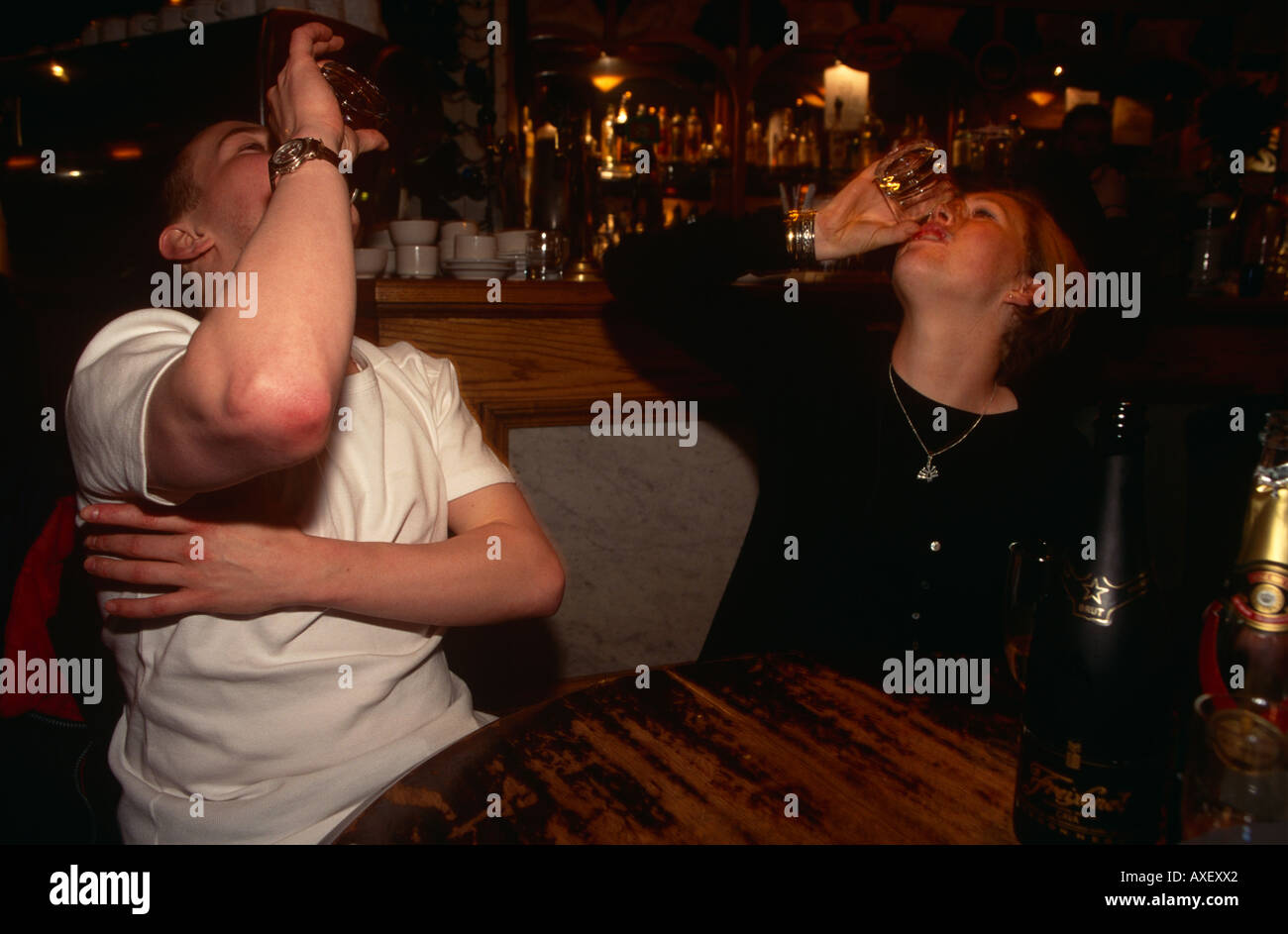 Due bevitori svuotare i loro bicchieri in un London wine bar. Foto Stock