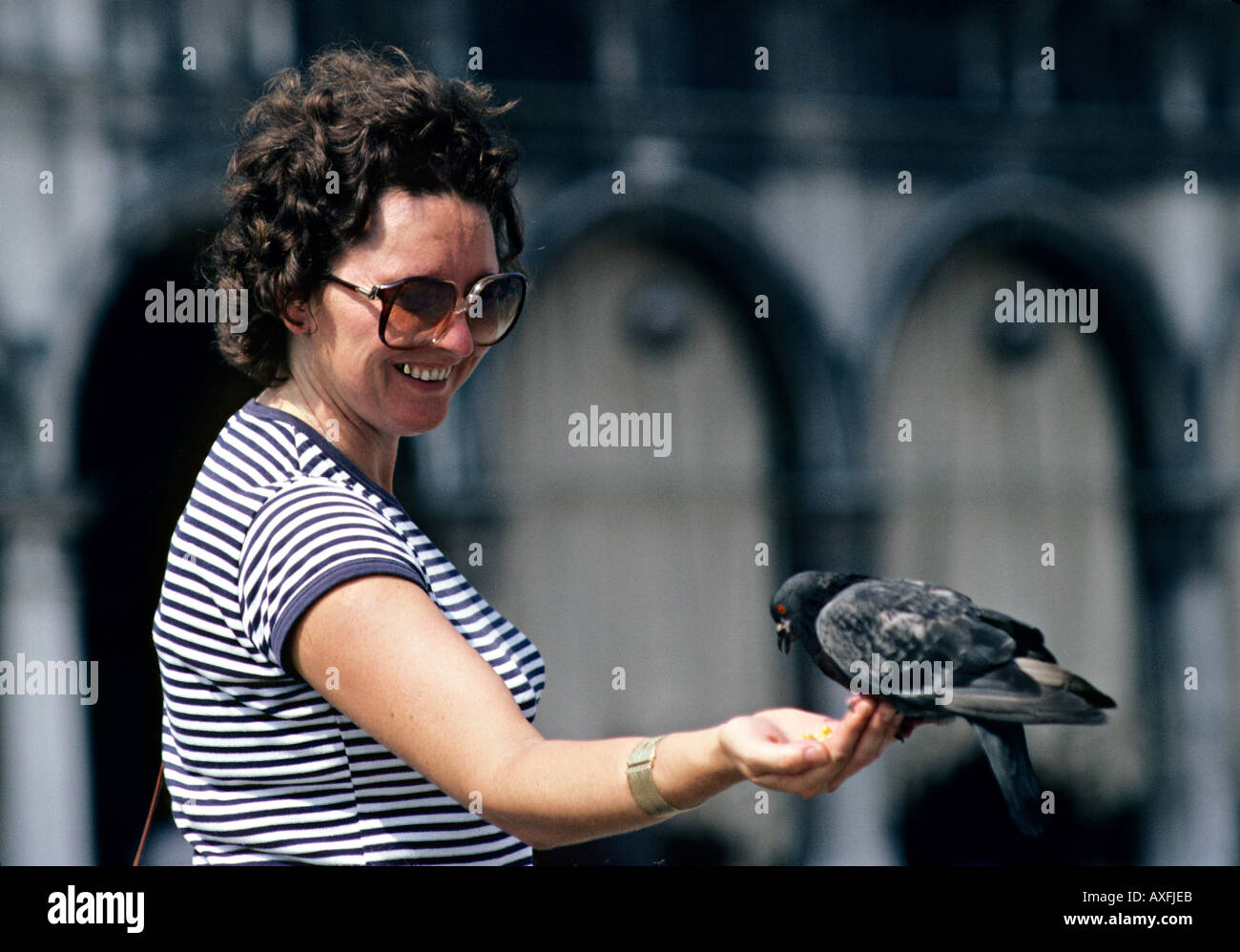 Donna piccione di alimentazione prima di influenza aviaria in Asia spaventare in Piazza San Marco Venezia Italia Foto Stock