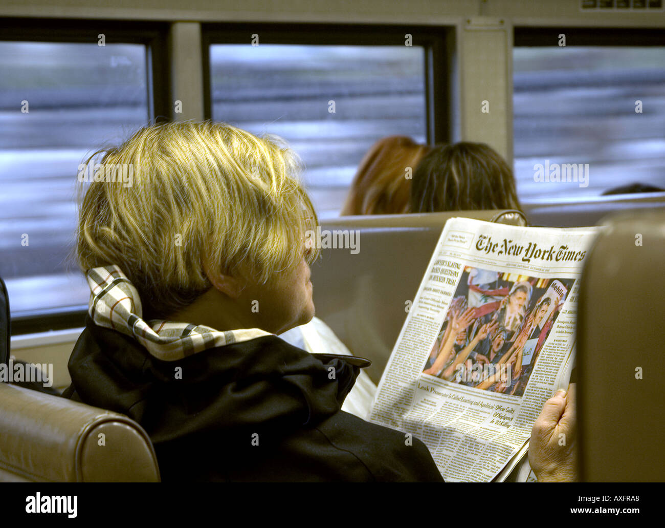 Una donna che legge il giornale mentre il pendolarismo su un treno per New York City. Foto Stock