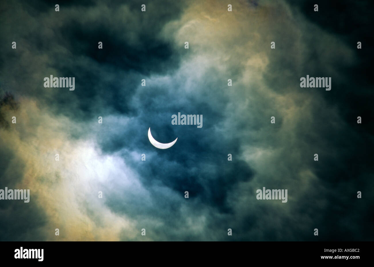 Eclissi solare. Luna passa davanti al sole quasi pieno di eclipse. Atmosfera romantica velata da sottili tempestoso cloud di compensazione Foto Stock