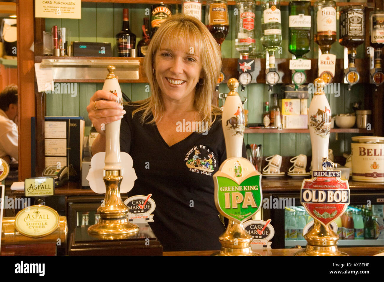 Un barista che serve in The Fox & Hounds Pub nel villaggio di Thurston nel Suffolk, Regno Unito Foto Stock