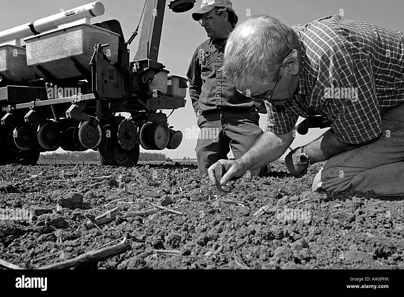 Due coltivatori controllano la profondità di un seme piantato come piantando stagione comincia nell'Ontario sudoccidentale, Canada. Foto Stock