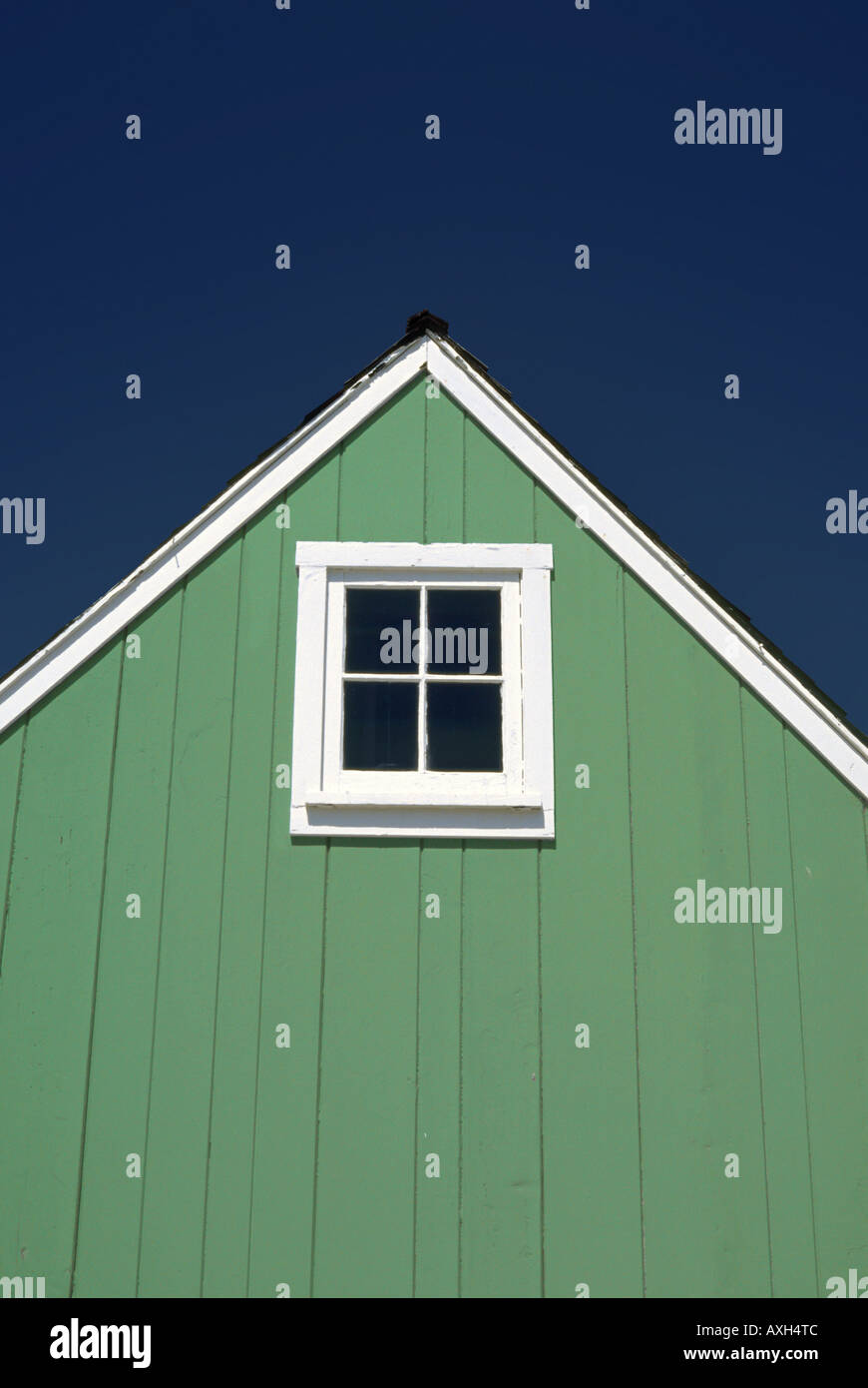 Piccola casa verde gable con un quadrato da quattro bianco vetrata finestra incorniciata Foto Stock