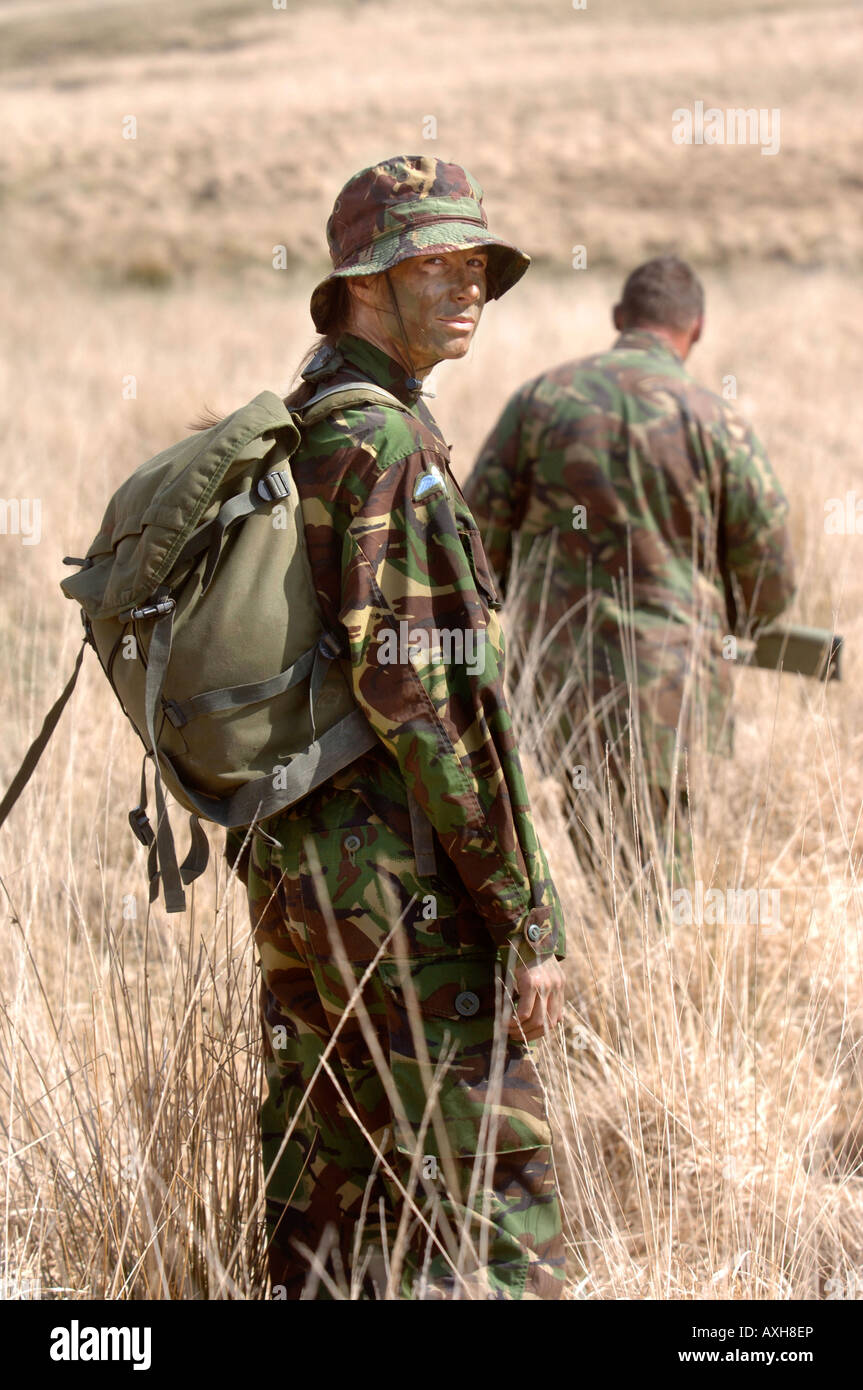 Un esercito britannico femmina segue un sergente di colore su di una levetta di formazione durante un corso di cecchino in Brecon Galles Wales Foto Stock