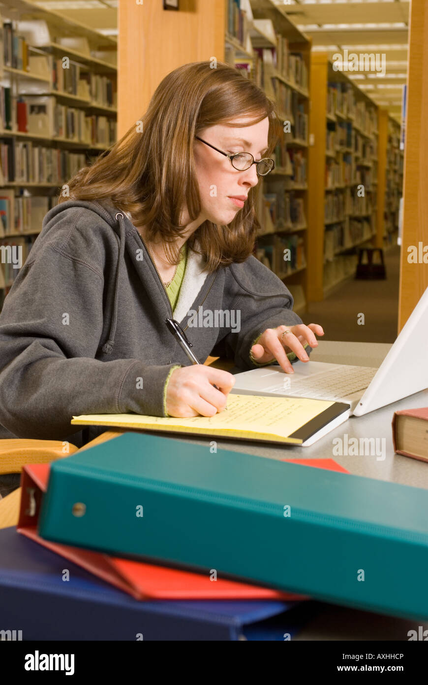 Una giovane donna studi nella libreria Foto Stock