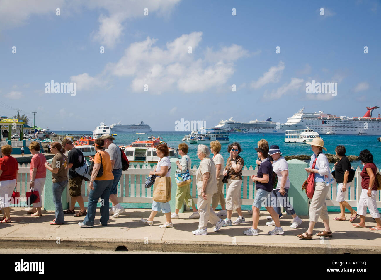 La nave di crociera i passeggeri a piedi in Georgetown waterfront con navi da crociera off Georgetown sull'isola di Grand Cayman in Cayman Islnads Foto Stock