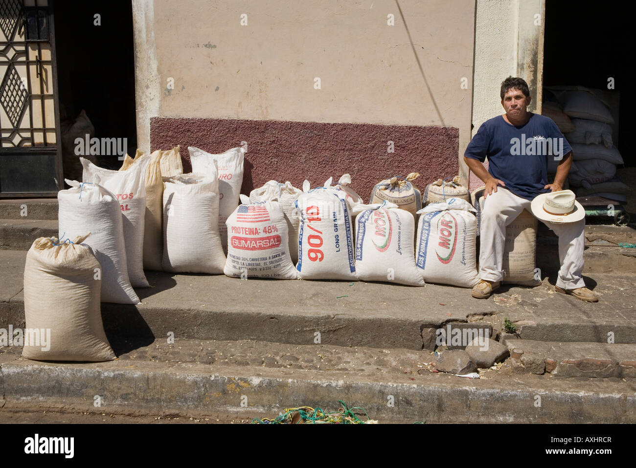 L'uomo possiede il negozio di avanzamento dei sacchi di riso e di grano in Suchitoto El Salvador Foto Stock